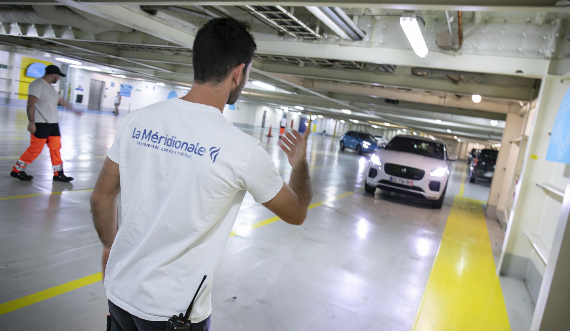 Personnel aidant à garer un véhicule à bord